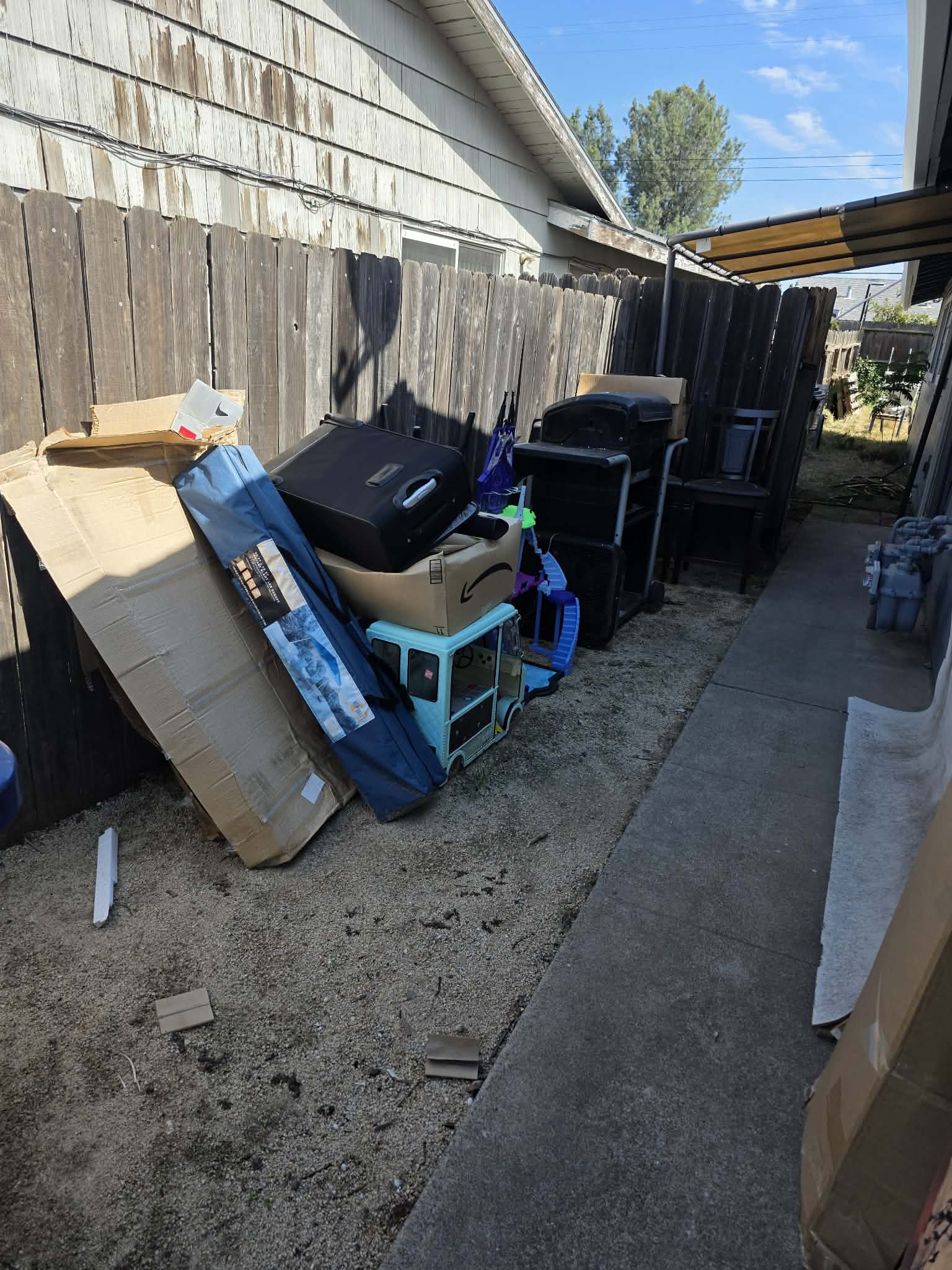 Clean Slate Hauling and Removal household junk piled by fence before pickup
