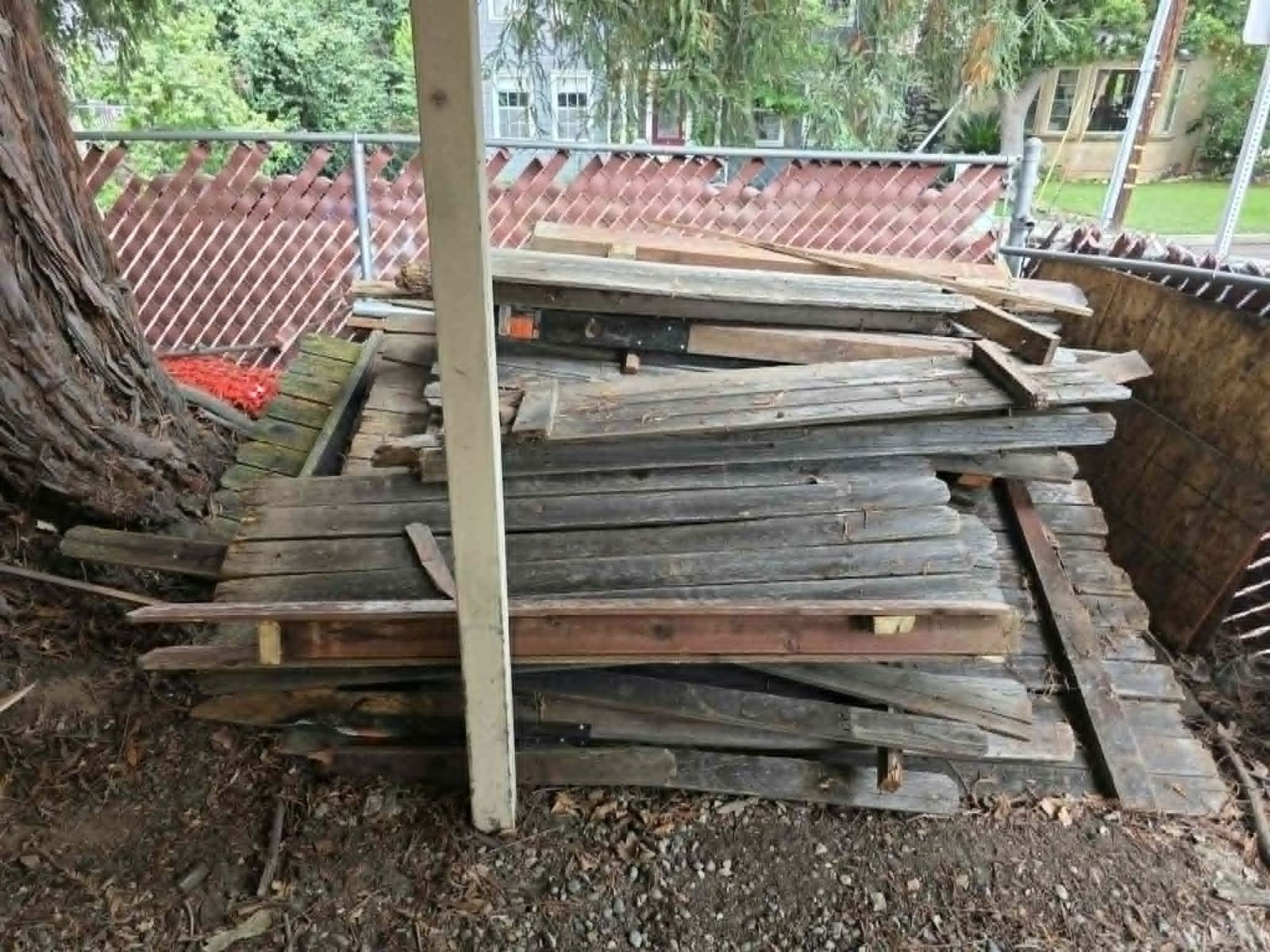 Clean Slate Hauling and Removal lumber stacked by fence